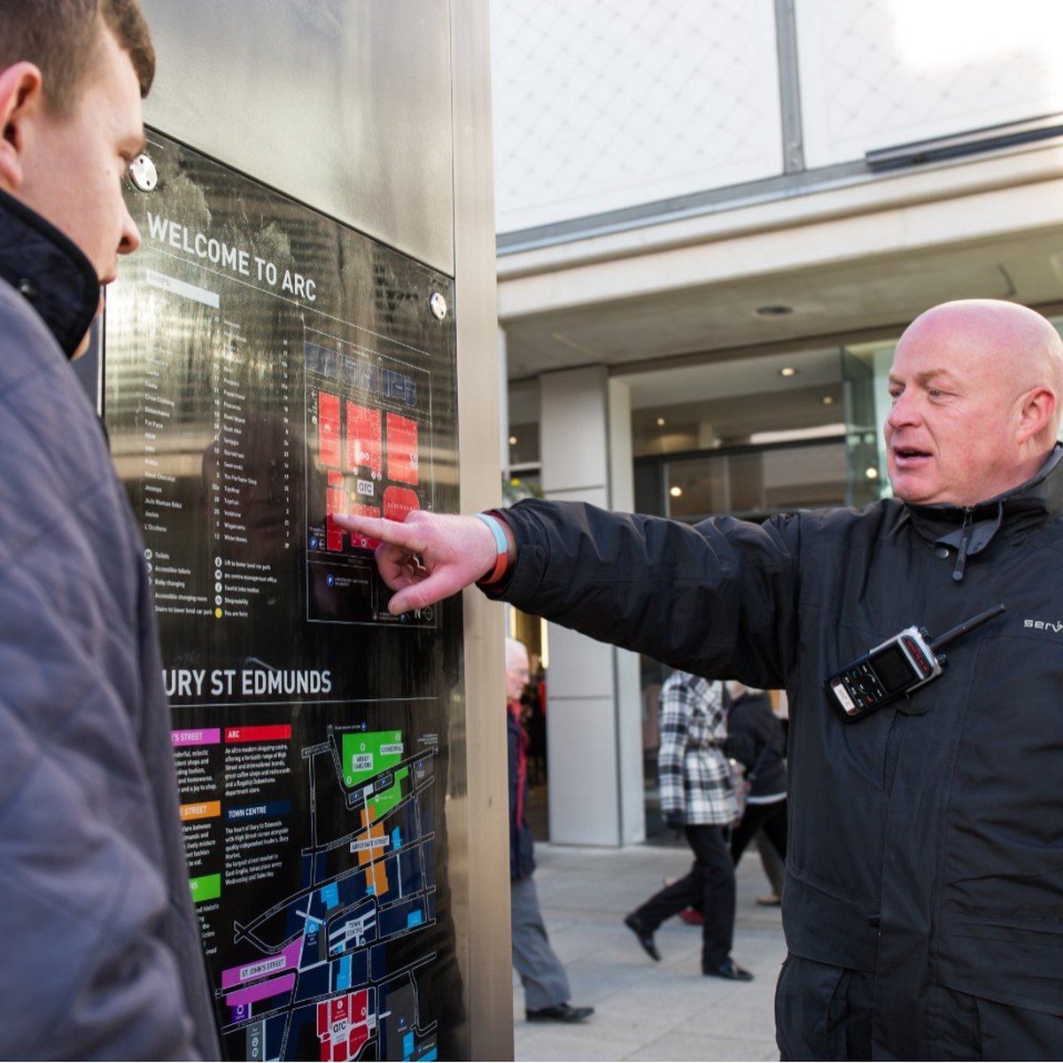 American Universal unarmed Security Guard in San Bernardino helping a customer that needs help finding a way to the train.